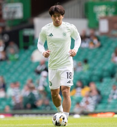 Yamada in Celtic training kit controls the ball on the pitch during a match warm-up.